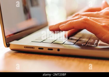 Close-up of male hands typing on the laptop keyboard. Stock Photo