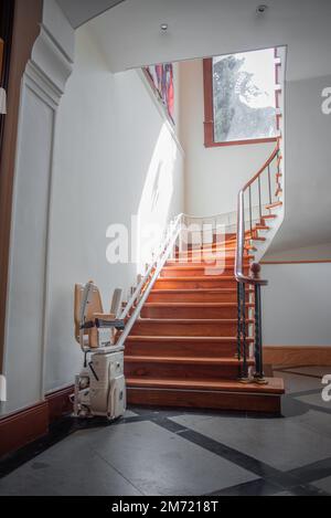 Tlatelolco, CDMX, 10 12 22, Antique stair lift with folding seat, luxurious circular wooden staircase, no people Stock Photo