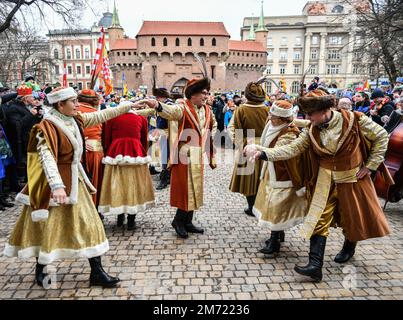 Krakow, Poland. 06th Jan, 2023. Participants of the procession dance a polonaise in front of the Florianska gate. Traditional Procession of the Three Kings. Three processions passed through the city to, in accordance with tradition, bow to Jesus on Krakow's Main Market Square. Credit: SOPA Images Limited/Alamy Live News Stock Photo