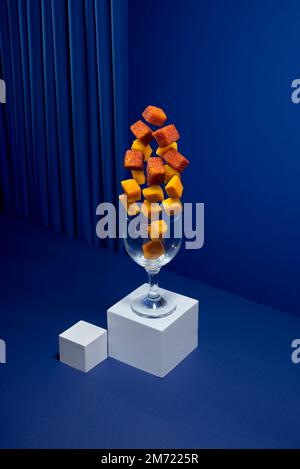 fresh cut mango cocktail with chili powder in a glass cup on a blue background, no people Stock Photo