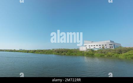 lake with calm water, green trees, blue sky and a building in the background, laguna del carpintero in tampico tamaulipas, cloudless vacation spot, no Stock Photo