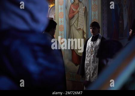Kherson, Ukraine. 06th Jan, 2023. An altar boy listens to father's prayer at the orthodox church. Orthodox Christmas celebration in the city of Kherson, Ukraine. This celebration coincided with the 36-hour ceasefire decreed by Russian President Vladimir Putin. Credit: SOPA Images Limited/Alamy Live News Stock Photo
