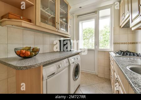 a kitchen area with a sink, stove and dishwasher on the counter in front of the washer