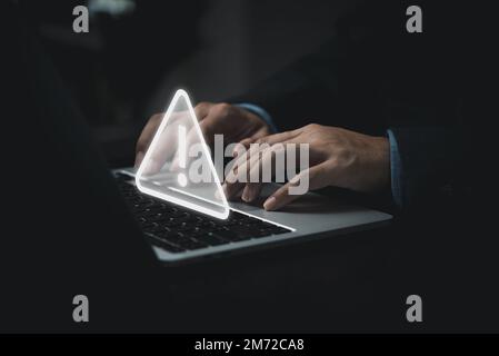 Businessman programmer, developer using laptop computer with triangle caution warning sign for notification error and maintenance concept. Stock Photo