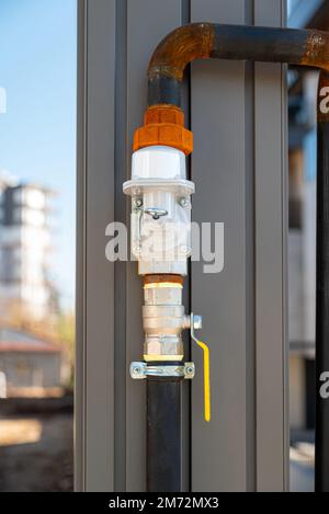 Natural gas pipe and valve mounted on the building column Stock Photo