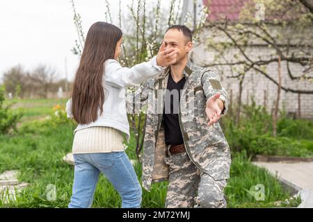 military reunion between father and daughter. military dad embracing his daughter on his homecoming. Army soldier Stock Photo