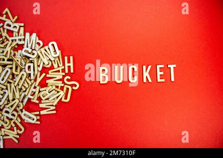 BUCKET in wooden English words language capital letters spilling from a ...