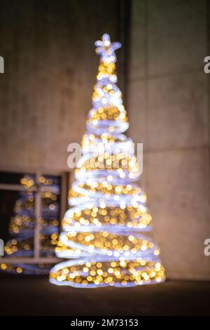 Defocused Christmas tree outdoors with bokeh balls and reflection Stock Photo