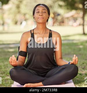 Young fit Black woman in seated balancing yoga pose exercising on