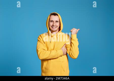 Cheerful handsome man pointing at copy space Stock Photo