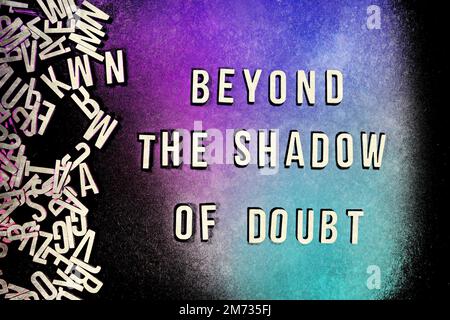 BEYOND THE SHADOW OF DOUBT in wooden English words language capital letters spilling from a pile of letters on a red background - water colour Stock Photo