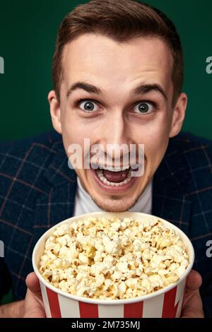 Young caucasian man in 3d glasses eating popcorn Stock Photo