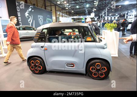 Riga,Latvia - April 29, 2022: People are enjoying about french small Citroen Ami electric two-seater micro-city car . Stock Photo