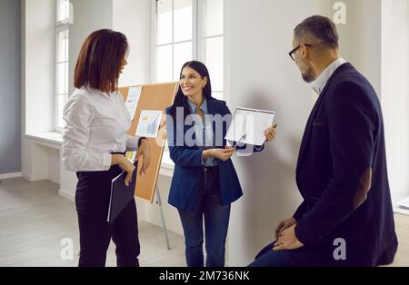 Group of confident business partners discussing document at meeting Stock Photo