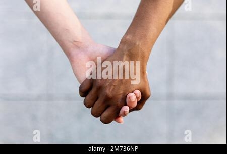 Close up shot of two diverse women holding hands showing unity and support Stock Photo