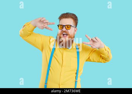 Funny bearded Caucasian man performs dance working as presenter or showman stands in studio Stock Photo
