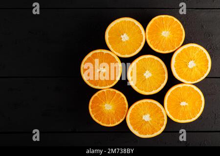 Fresh ripe oranges on a dark wooden table. Fresh citrus fruits for vegetarian dishes Stock Photo