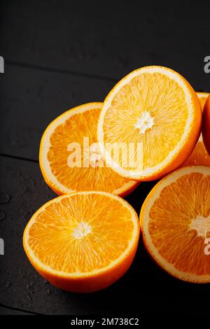 Fresh ripe oranges on a dark wooden table. Fresh citrus fruits for vegetarian dishes Stock Photo