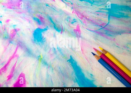 Primary colors watercolor abstract textured background with three primary colors sharpened pencils in the lower right corner Stock Photo