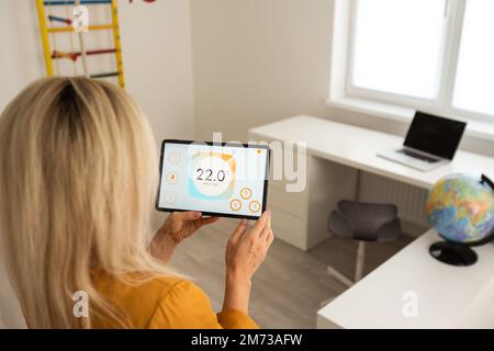 Woman using smart wall home control system. Stock Photo