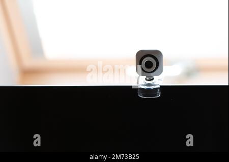 Webcam above computer screen. White webcam above black screen. Digital security concept Stock Photo