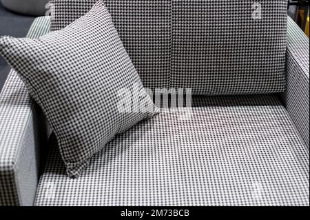 small sofa with a stylish pillow, variegated fabric in black and white tones Stock Photo