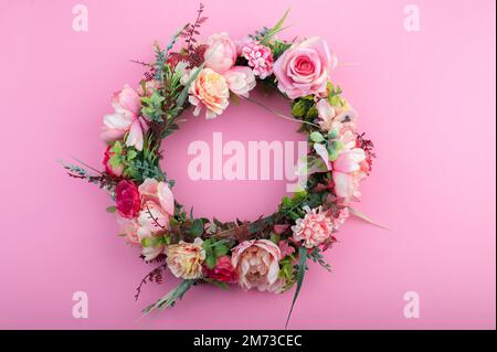 Colorful artificial flowers wreath isolated on pink background Stock Photo