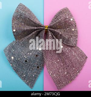 Burlap bow with gold glitter on pastel background, Christmas holiday decor Stock Photo