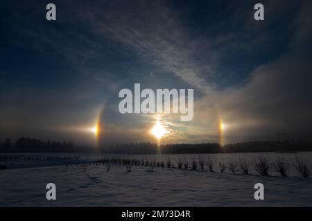 Sunset in the winter and natural atmospheric phenomenon Halo, parhelion, parhelia, sundog in Latvia Stock Photo