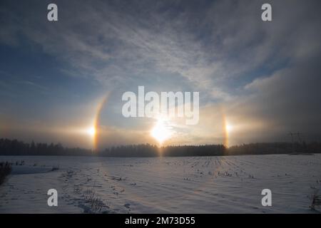 Sunset in the winter and natural atmospheric phenomenon Halo, parhelion, parhelia, sundog in Latvia Stock Photo