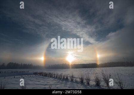 Sunset in the winter and natural atmospheric phenomenon Halo, parhelion, parhelia, sundog in Latvia Stock Photo