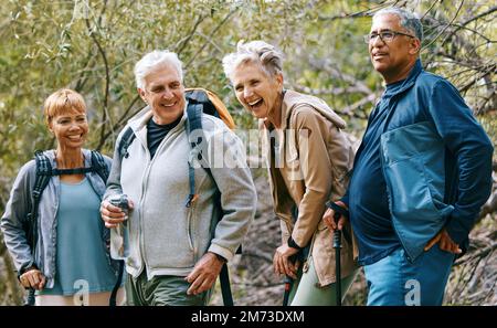 Nature, hiking and happy senior friends bonding, talking and laughing at comic joke in forest. Happiness, fun and group of elderly people trekking Stock Photo