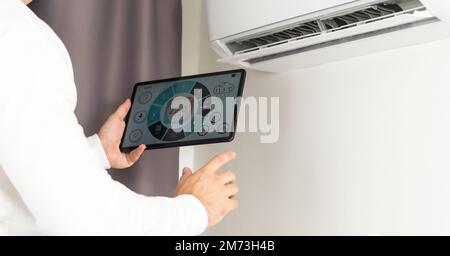 Smart home control on tablet. Interior of living room in the background Stock Photo