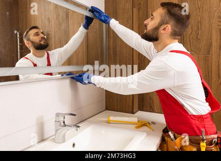 the man fixes the mirror Stock Photo