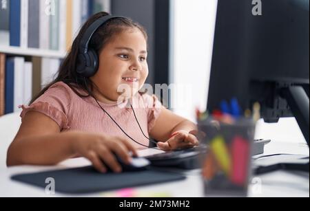 Plus size hispanic girl student using computer and headphones sitting ...