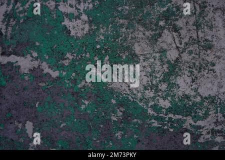 Old grunge concrete wall mottled with traces of past paint layers of green and silver color. Grunge design background Stock Photo