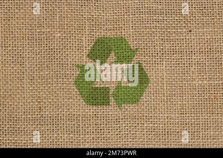 Recycling logo symbol on a hessian sack cloth material background Stock Photo