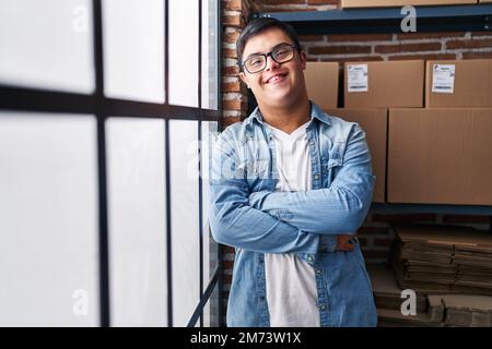 Down syndrome man ecommerce business worker standing with arms crossed gesture at office Stock Photo