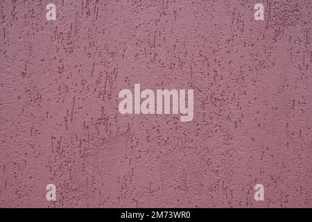 Closeup of plastered exterior wall painted in mauve purple color. Indented texture background. Stock Photo