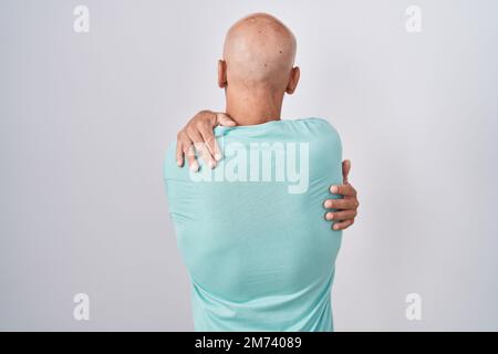Middle age bald man standing over white background hugging oneself happy and positive from backwards. self love and self care Stock Photo