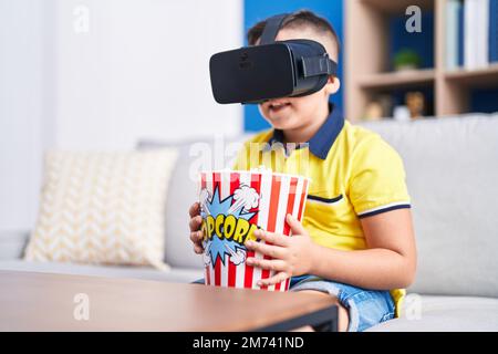 Adorable hispanic boy watching 3d movie sititng on sofa at home Stock Photo