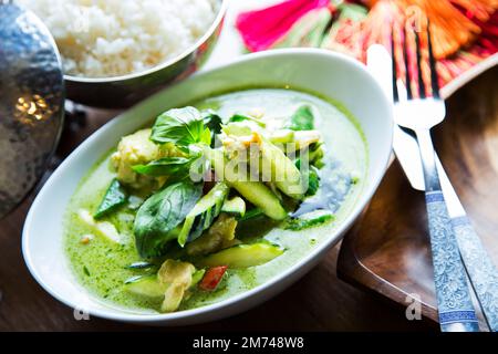 Green Asian curry soup with meat and vegetables served in a bowl. Stock Photo