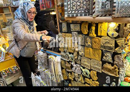 (230107) -- CAIRO, Jan. 7, 2023 (Xinhua) -- A tourist buys souvenirs the famed tourist bazaar Khan el-Khalili in Cairo, Egypt, on Jan. 6, 2023. Shop owners in Khan el-Khalili, one of the most famed tourist bazaars in the Egyptian capital Cairo, are expecting the return of Chinese guests after China announced its easing of travel restrictions starting from Jan. 8. TO GO WITH 'Roundup: Egypt's famed bazaar welcomes return of Chinese tourists' (Xinhua/Ahmed Gomaa) Stock Photo