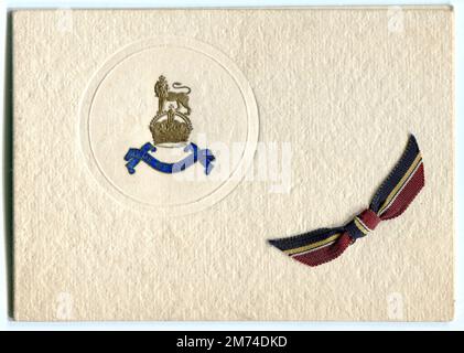 A Second World War period greetings card produced for members of the British Army unit, The Army Pay Corps. The card is decorated with the corps' cap badge and a ribbon in the colours of its regimental tie. 1940s. Stock Photo