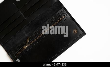 Open empty handmade brown man's genuine leather wallet with zipper on a button for banknotes and credit cards isolated on white background. Stock Photo