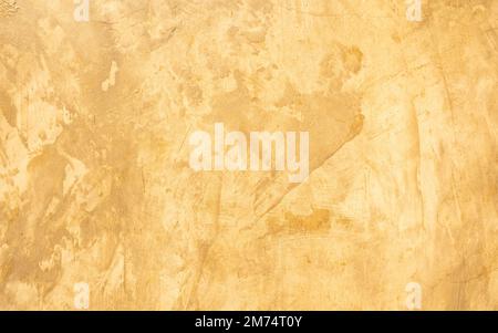 Abstract grunge decorative golden stucco wall with scratches, scuffs background. Art-stylized texture banner with copy space. Stock Photo