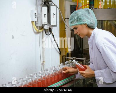 Nutritionists checking the quality of the herbal drinks check the quality of drink basil seed produces on a conveyer belt before distribution to marke Stock Photo