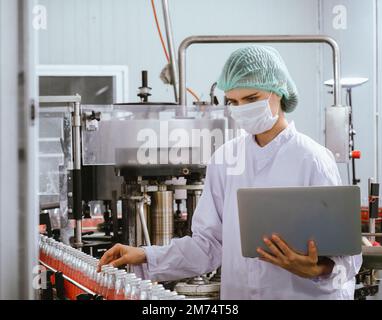 Nutritionists checking the quality of the herbal drinks check the quality of drink basil seed produces on a conveyer belt before distribution to marke Stock Photo