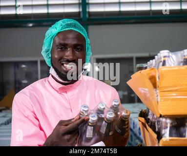 Nutritionists checking the quality of the herbal drinks check the quality of drink basil seed produces on a conveyer belt before distribution to marke Stock Photo