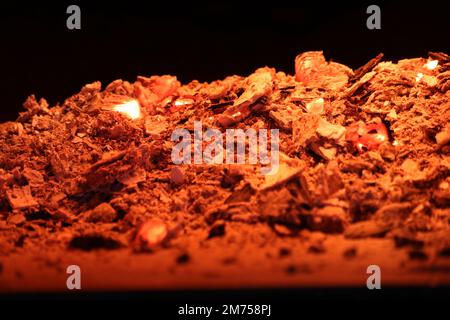 Red-hot charcoal and ash on a black background. Stock Photo